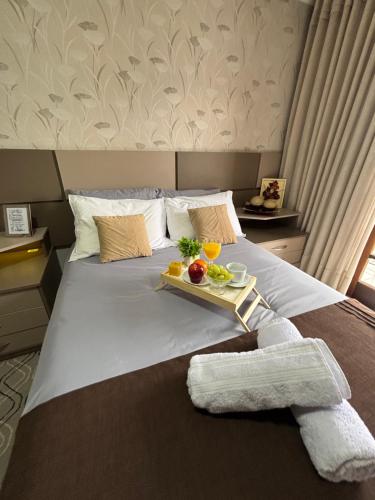 a bed with a tray of fruit on it at Casa Confortável 03 Quartos Com Suite, Churrasqueira, Banheira e Garagem in Curitiba