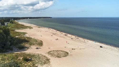 a group of people on a beach near the water at The Grand Nyborg Stay in Nyborg