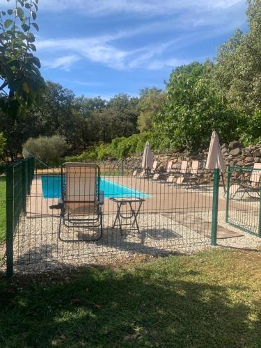 a fence with a table and chairs next to a pool at CASA PARVATHI CANDELEDA in Candeleda