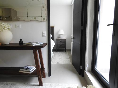 Un pasillo con un espejo, una mesa y una lámpara en Cozy and relax Apartment, en Puerto Natales