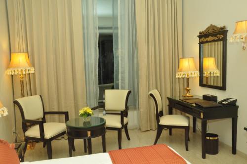 a hotel room with a desk and a bed and a room at Royal Tulip Navi Mumbai in Navi Mumbai
