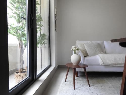 sala de estar con sofá y jarrón sobre una mesa en Cozy and relax Apartment, en Puerto Natales