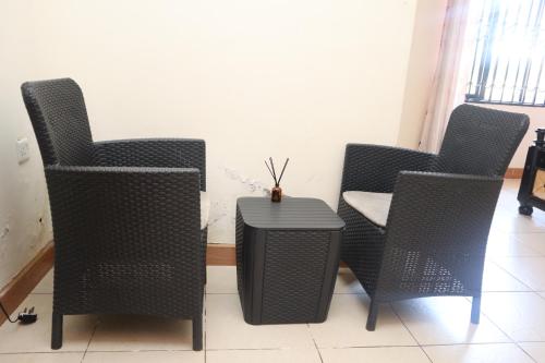 a group of chairs and a table in a room at Namulanda Motel in Entebbe