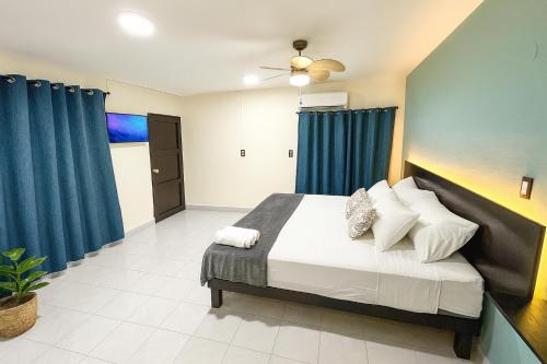 a bedroom with a large bed with blue curtains at Habitaciones Bacalar MYD in Bacalar