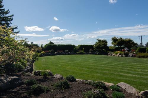 a large yard with green grass and rocks at Private Family Home With Gorgeous Yard in Camas