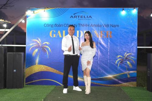 a man and a woman standing in front of a banner at Quan Lan Nam Phong Hotel in Quan Lạn