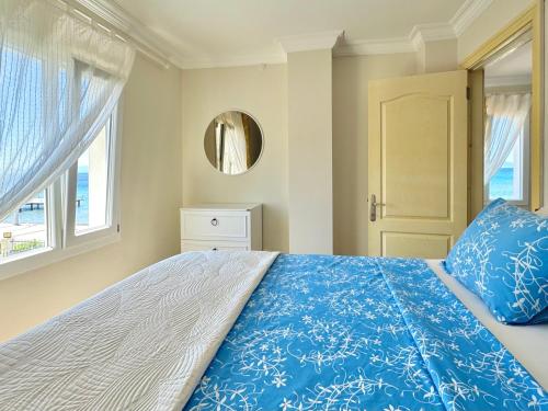 a bedroom with a bed with a blue comforter and a window at VITAMIN SEA Apartment in Özdere