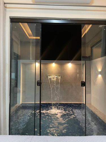 a pool with a fountain in the middle of a house at Casa Solar Beach in Vilhena