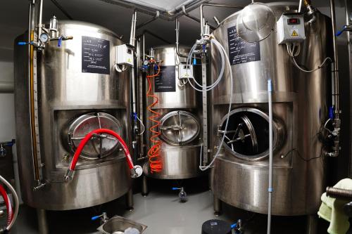 a row of metal tanks in a brewery at Penzion Markus - Pivovar - Brewery Frymburk in Frymburk