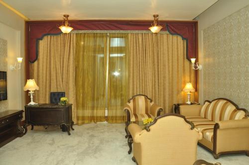 a living room with two chairs and a window at Royal Tulip Navi Mumbai in Navi Mumbai