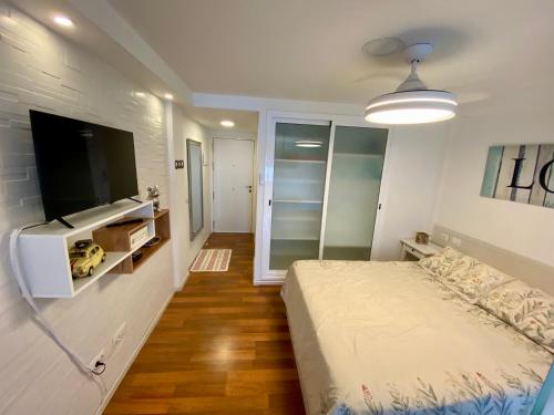 a bedroom with a bed and a flat screen tv at LOFT vistas playa jardin in Puerto de la Cruz