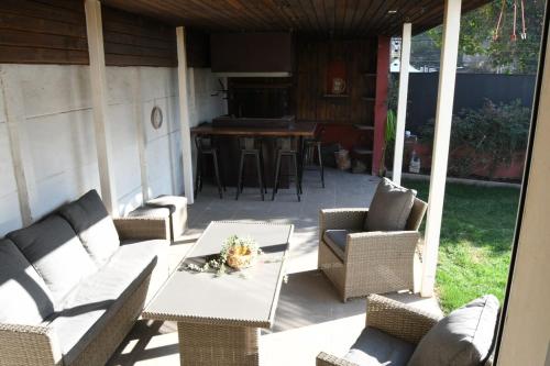 a patio with wicker chairs and a table and a bar at Spacious and beautiful house in Las Condes in Santiago