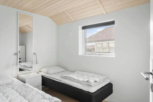 une chambre avec deux lits et une fenêtre dans l'établissement M226-Vaeggerlose-Marielyst-Strandpark-253, à Bøtø By