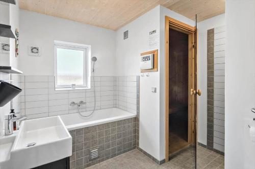 une salle de bain avec une baignoire, un lavabo et une douche dans l'établissement M226-Vaeggerlose-Marielyst-Strandpark-253, à Bøtø By