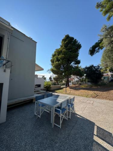 a table and chairs sitting next to a building at Akti elia apartment in Kalogria