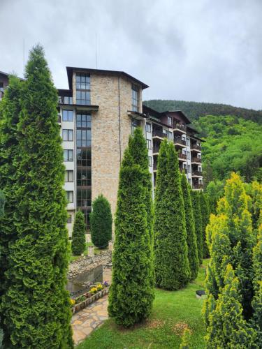 a building with a bunch of trees in front of it at Студио Бети Балнео Спа Хотел Свети Спас in Velingrad