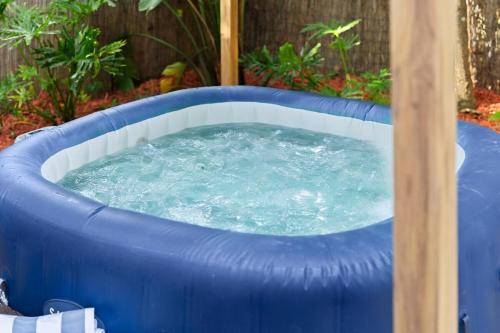 Un jacuzzi inflable azul en un patio trasero. en The Boho Jungalow - Private, HotTub, Downtown, en Orlando