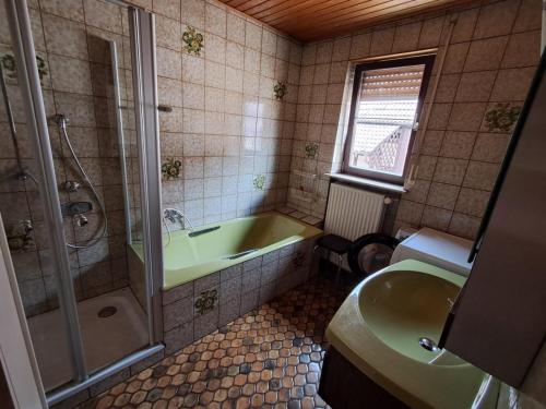 a bathroom with a tub and a shower and a sink at Haus mit zwei Ferienwohnungen in Boxtal