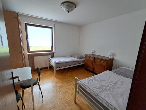 a bedroom with a bed and a desk and a window at Haus mit zwei Ferienwohnungen in Boxtal