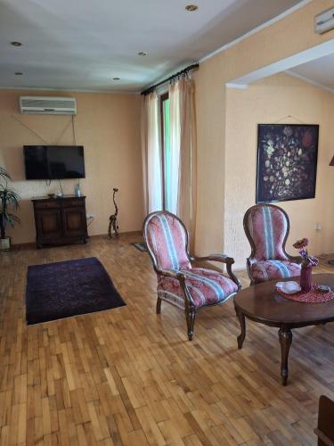 Una sala de estar con dos sillas y una mesa. en Seven Heaven, en Sremčica