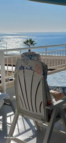a chair sitting on a balcony with the ocean at Residencial Aguilas Playa in Águilas