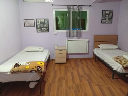 ワディ・ムーサにあるMonasteryの木製の床の部屋にベッドが2つあります