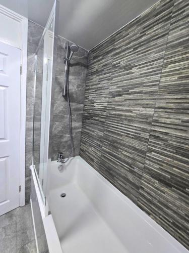 a bathroom with a bath tub and a shower at Hertfordshire - Stylish 6BR Retreat, 3 Parking in Stevenage