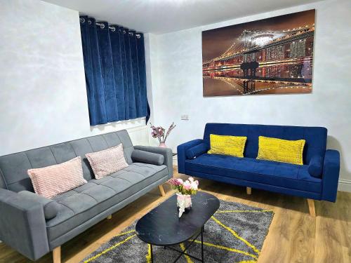 a living room with two blue couches and a table at Hertfordshire - Stylish 6BR Retreat, 3 Parking in Stevenage