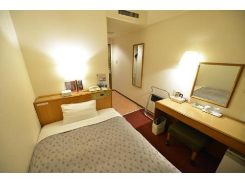 a bedroom with a bed and a desk and a mirror at Smile Hotel Tokyo Shinkoiwa - Vacation STAY 82154v in Tokyo