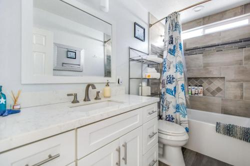 a bathroom with a sink and a toilet and a mirror at Relax Explore from Mission Viejo Pool Spa in Mission Viejo