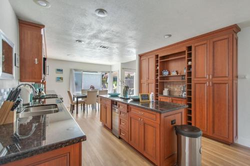 a kitchen with wooden cabinets and a dining room at Relax Explore from Mission Viejo Pool Spa in Mission Viejo