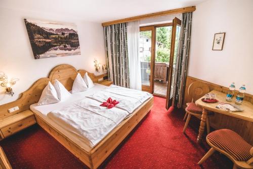 a bedroom with a bed with a bow on it at Hotel Metzgerwirt in Kirchberg in Tirol