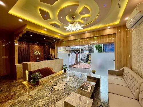 a lobby with a couch and a chandelier at The Little Heaven Hotel near Kolkata Airport in kolkata