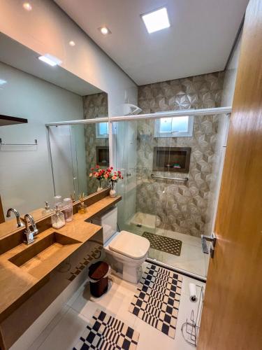 a bathroom with a shower and a toilet and a sink at Casa Zeluz in Chapada dos Guimarães