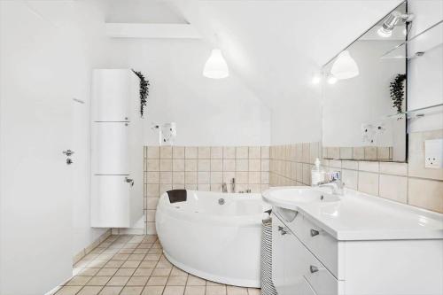 a white bathroom with a tub and a sink at M318-Vaeggerlose-Marielyst-Strandvej-63-S in Marielyst
