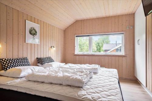 a large white bed in a room with a window at M197-Vaeggerlose-Musestien-6 in Marielyst