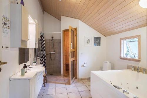 a bathroom with a tub and two sinks and a shower at M197-Vaeggerlose-Musestien-6 in Marielyst