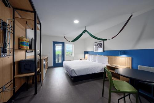 a bedroom with a bed and a desk and a table at LOGE Missoula in Missoula