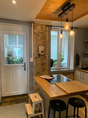 a kitchen with a counter and a table and chairs at Appartement authentique et chaleureux au cœur de Salies-de-Béarn, dans le quartier historique avec commerces et restaurants au pied, à deux pas des thermes in Salies-de-Béarn