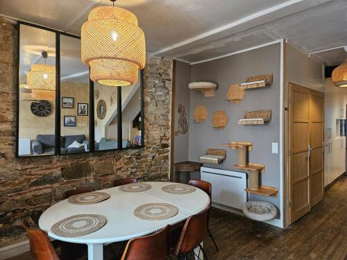 a dining room with a white table and chairs at Appartement authentique et chaleureux au cœur de Salies-de-Béarn, dans le quartier historique avec commerces et restaurants au pied, à deux pas des thermes in Salies-de-Béarn