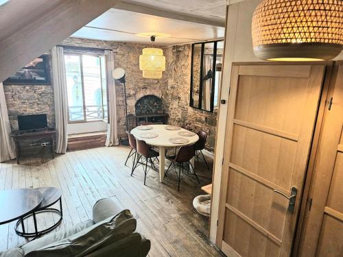 a dining room with a table and chairs at Appartement authentique et chaleureux au cœur de Salies-de-Béarn, dans le quartier historique avec commerces et restaurants au pied, à deux pas des thermes in Salies-de-Béarn