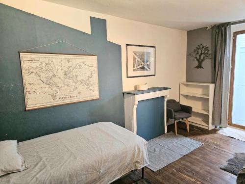 a bedroom with a bed and a map on the wall at Appartement authentique et chaleureux au cœur de Salies-de-Béarn, dans le quartier historique avec commerces et restaurants au pied, à deux pas des thermes in Salies-de-Béarn