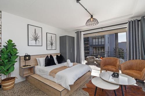 a bedroom with a large bed and a living room at Lira On White Soil in Cape Town