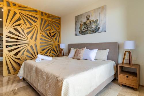 a bedroom with a bed and a painting on the wall at Luxury Penthouse with Ocean Views and Private Pool in Playa del Carmen