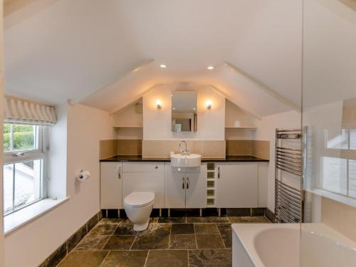 a bathroom with a sink and a toilet and a tub at 4 Bed in Polruan PC044 in Fowey