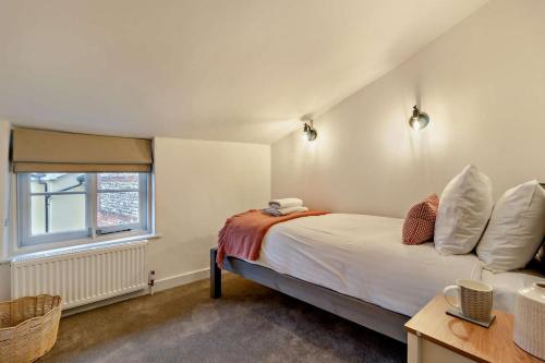 a bedroom with a bed and a window at Hawker Cottage in Lavenham