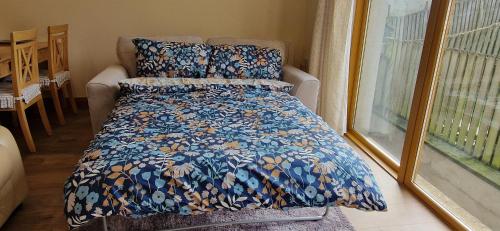 a bed with a blue comforter in a room at Tinahely Rest in Tinahely