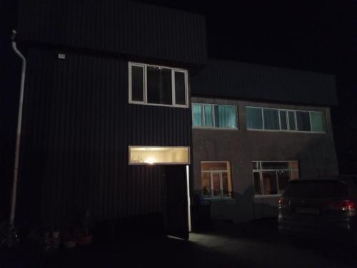 a building with a door in the dark at Guest House StarSky in Karakol