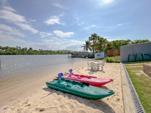 trois kayaks assis sur la plage au bord de l'eau dans l'établissement Vila das Carnaúbas | 2 chalés (Chalés Buriti e Atins), à Barreirinhas