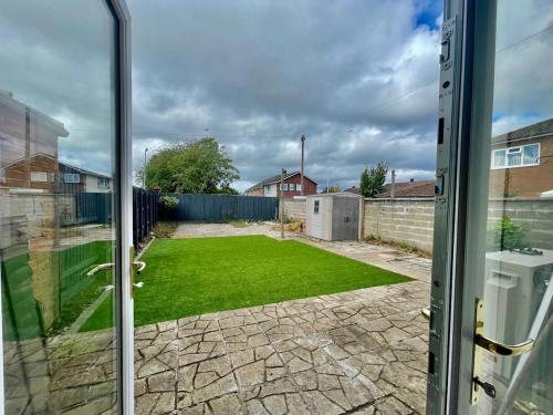 ein Blick auf einen Hof von einer Glasschiebetür in der Unterkunft Modern House with Garden and Parking in Cardiff